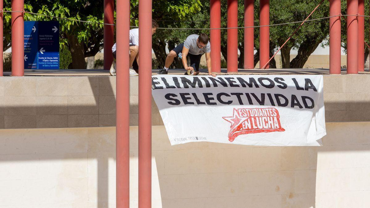 Estudiantes de la UA colocan una pancarta contra la Selectividad.