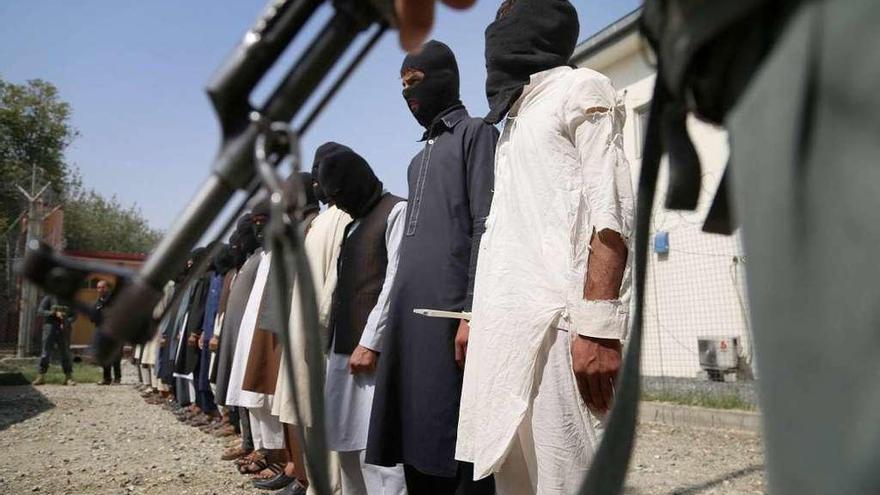 Policías afganos vigilan a un grupo de hombres acusados de terrorismo en Jalalabad.