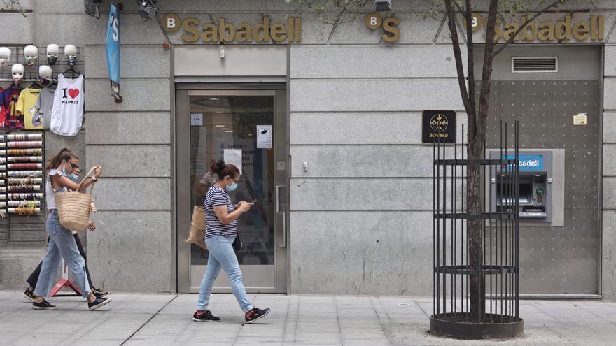 Varias personas pasan por una sucursal de Banco Sabadell.ptiembre de 2021, en Madrid (España).