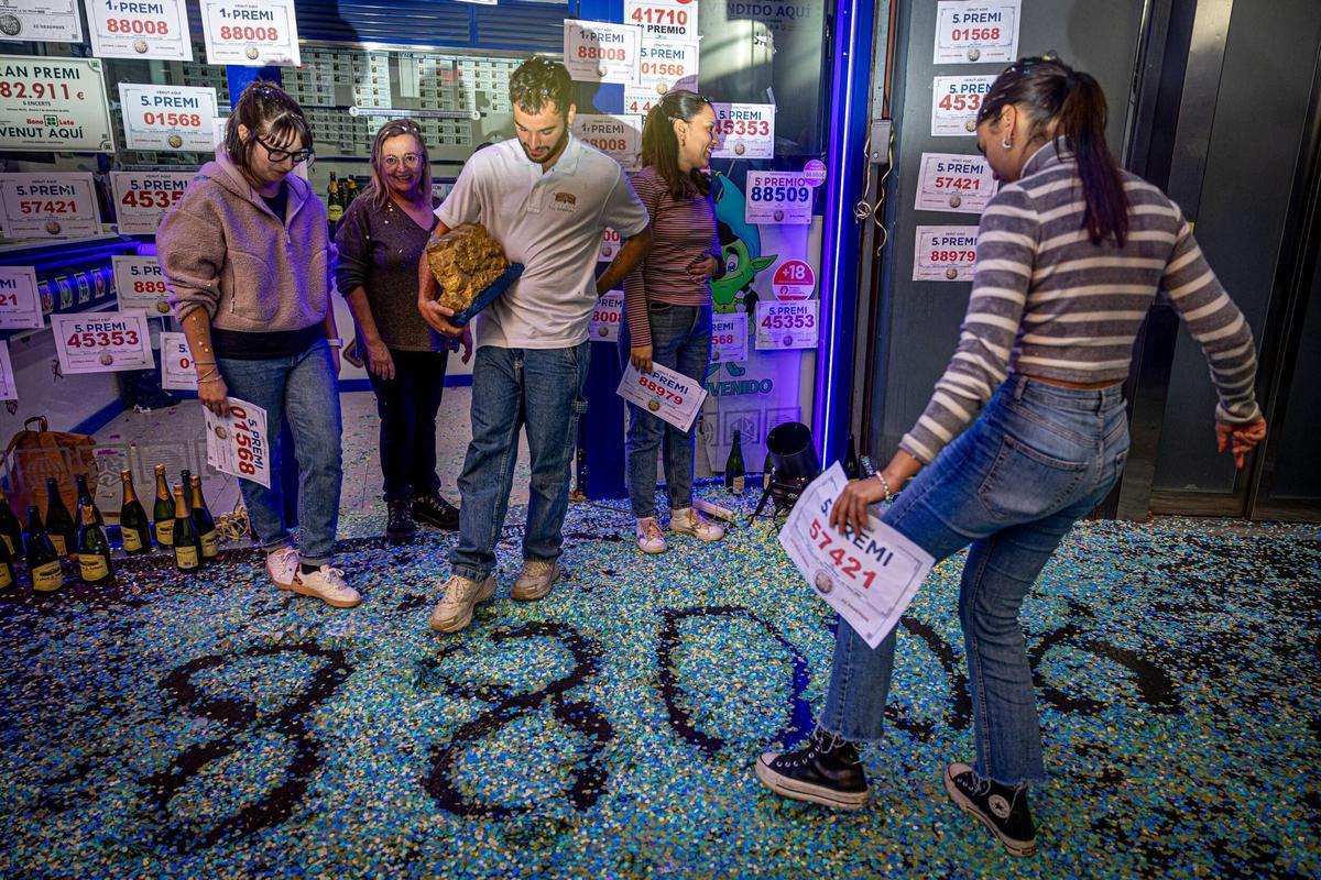 El 88008, número premiado con el Gordo de Navidad 2023, dibujado entre el confeti esparcido por el suelo, en la administración de lotería del centro comercial Arenas, en Barcelona. El local repartió parte del primer premio y cuatro quintos premios del sorteo