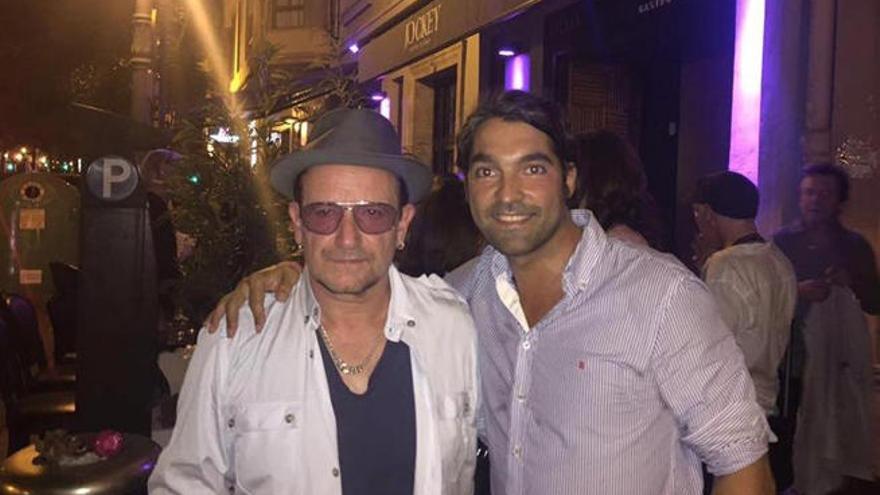 Bono posa con el propietario del local.