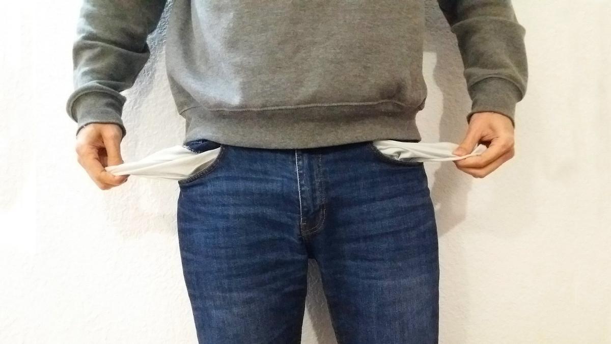 Un hombre muestra sus bolsillos del pantalón