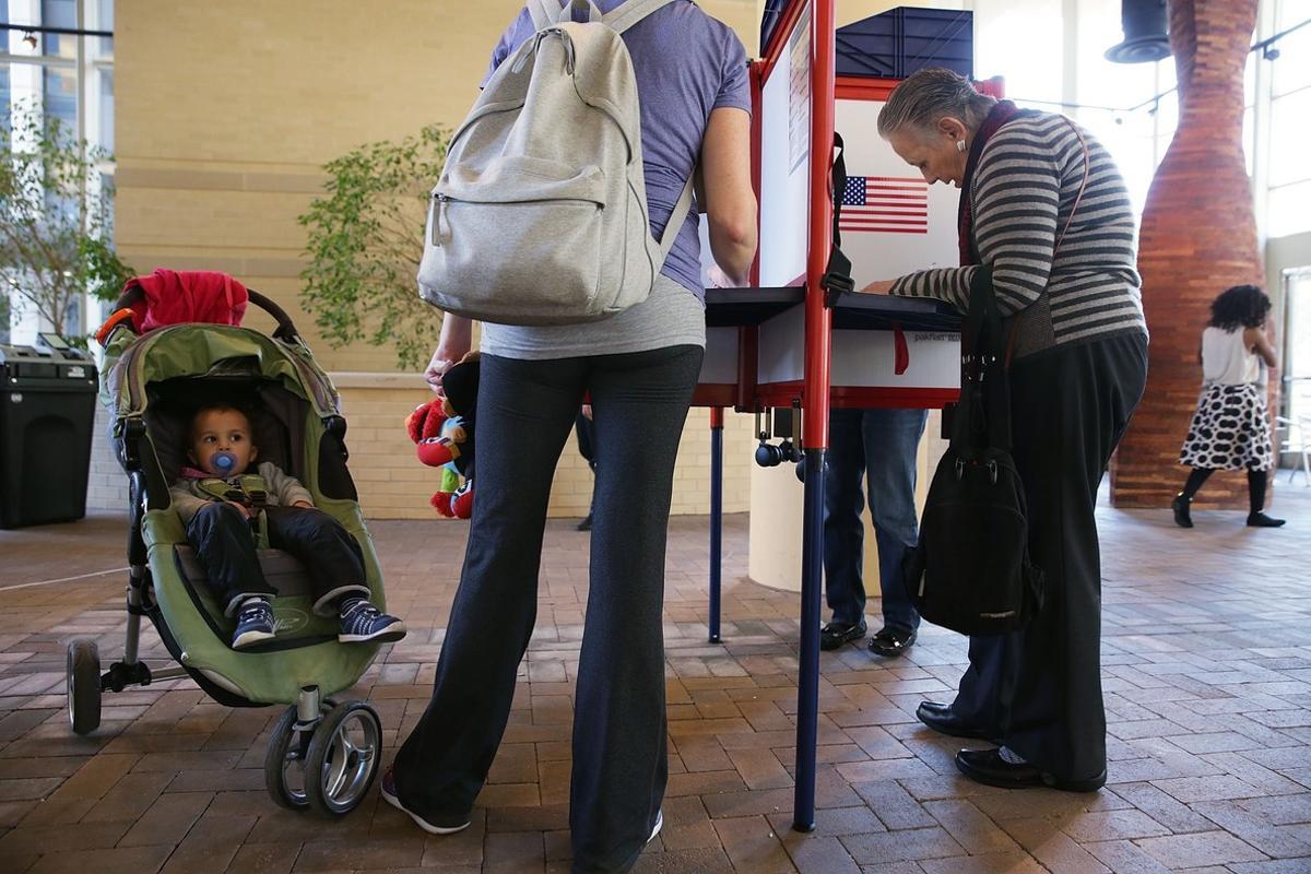 ARLINGTON, VA - NOVEMBER 08: An unidentified toddler watches his mother fill out a paper ballot in a polling place on Election Day November 8, 2016 in Arlington, Virginia. Americans across the nation pick their choice for the next president of the United States.   Alex Wong/Getty Images/AFP