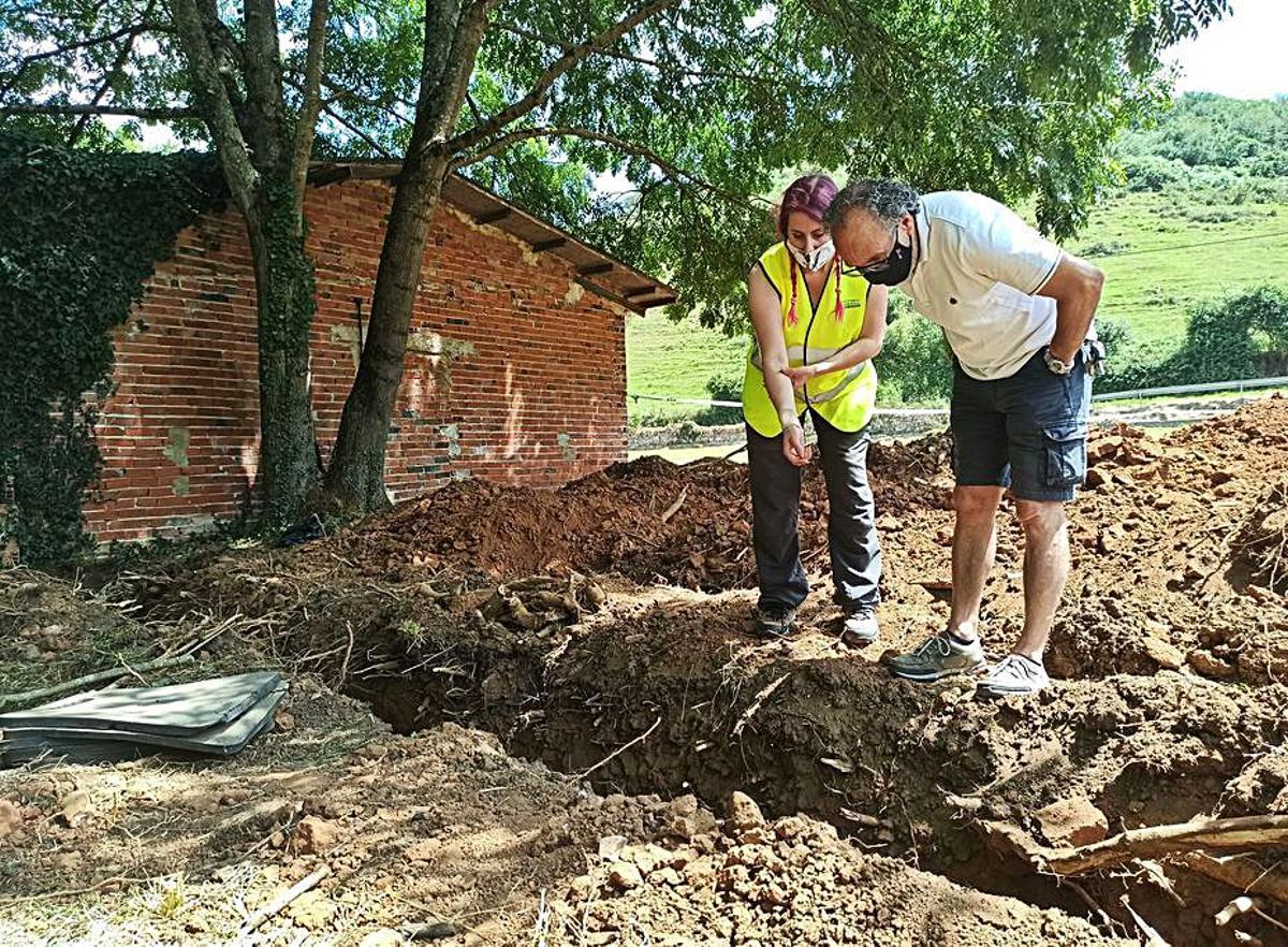 La arqueóloga Arantza Margolles y Ramón Miranda, vecino de Grado, en El Rellán, donde este cree que tiene a un tío enterrado. Abajo, Sabino Fernández. | Sara Arias
