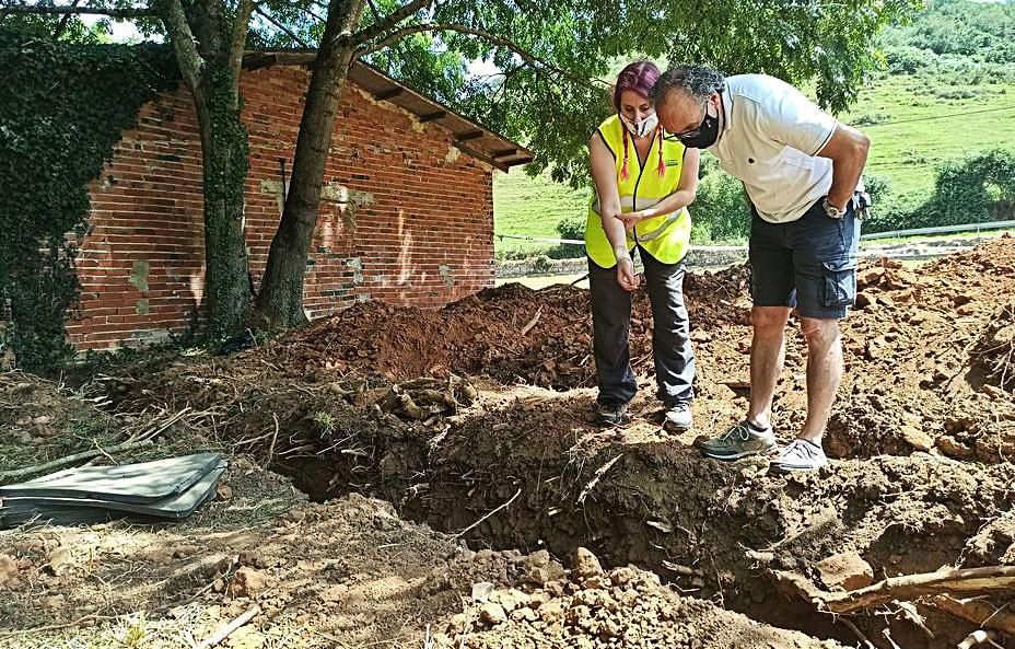 La arqueóloga Arantza Margolles y Ramón Miranda, vecino de Grado, en El Rellán, donde este cree que tiene a un tío enterrado. | Sara Arias