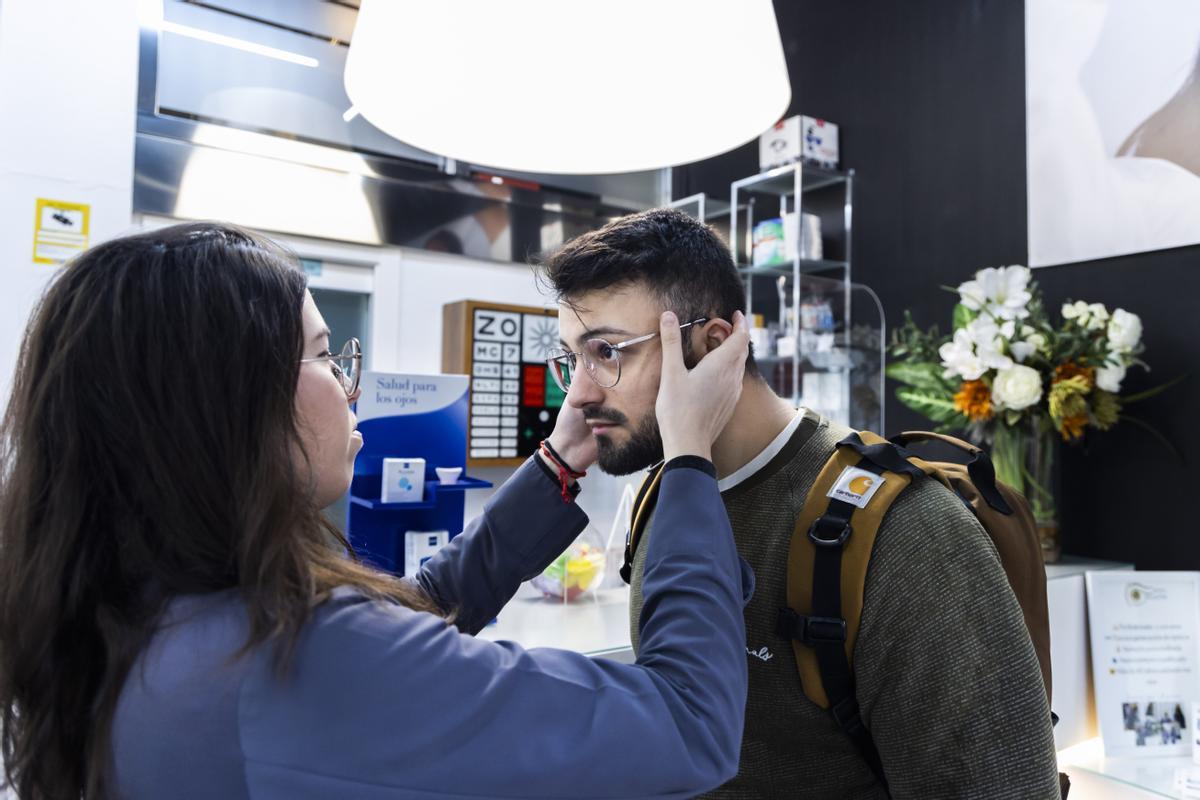 Un cliente se prueba unas gafas en una óptica de Valencia.