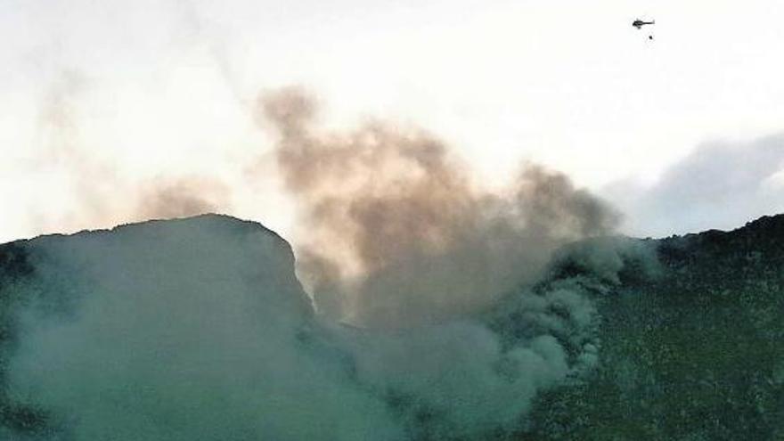 Arriba, un helicóptero durante las tareas de extinción. A la izquierda, el incendio desde Llanes | e. g. cea / m. t.