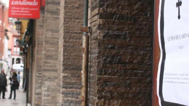 La calle de los bares, Valdés Pumarino, con una esquela anunciando el cierre anticipado del lunes de Carnaval. | braulio fernández