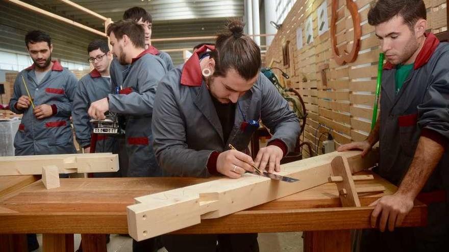 Estudiantes del CIFP A Xunqueira trabajando la madera en Edugal. // Rafa Vázquez