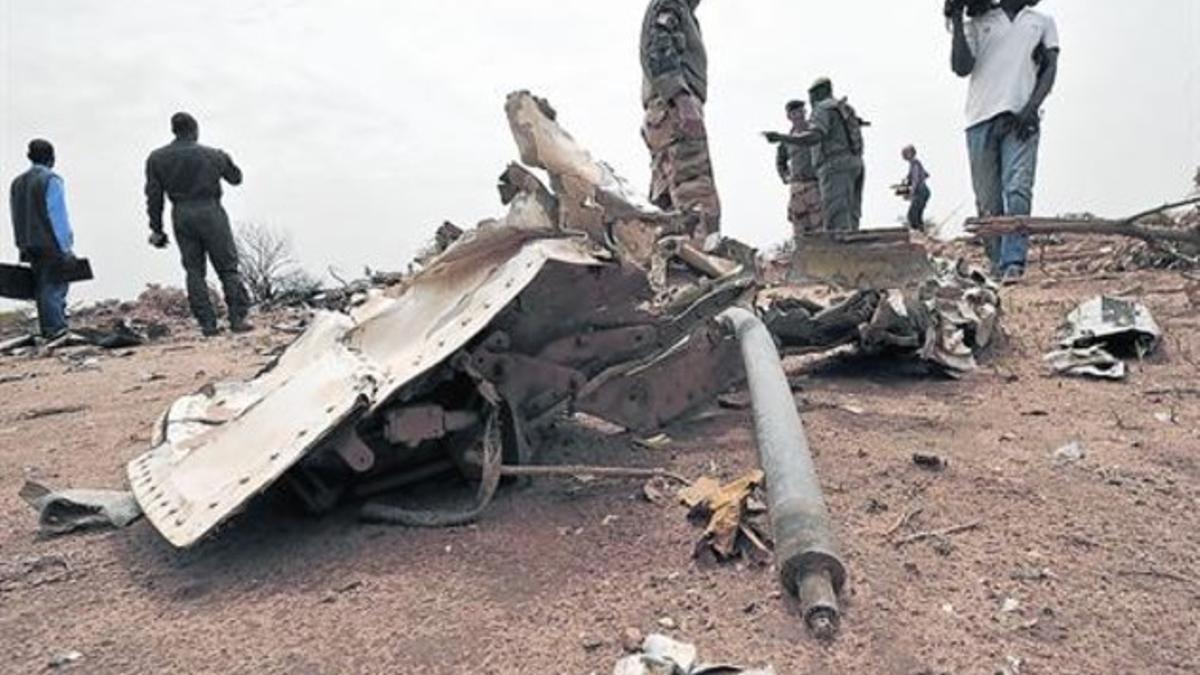 Un soldado francés y un cámara de televisión maliense junto a restos del fuselaje del avión de Swiftair, ayer.