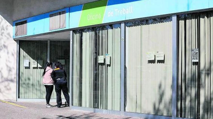 Una dona s’informa a l’entrada d’una Oficina de Treball  | ARXIU/ANIOL RESCLOSA