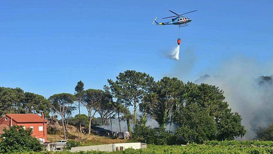 El helicóptero suelta agua sobre el incendio.