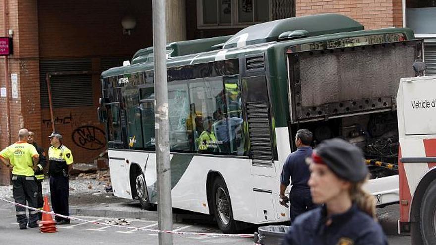 Vista del autobús accidentado en la esquina de la calle Dante con Conca de Tremp de Barcelona, después de que al parecer el conductor haya perdido el control del vehículo, que se ha estrellado con un edificio y ha provocado la muerte de dos personas, una niña y una mujer, así como nueve heridos.