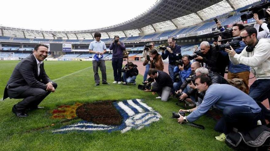 Eusebio Sacristán posa para los medios ante el escudo de la Real Sociedad, ayer en Anoeta, durante su presentación. // Juan Herrero