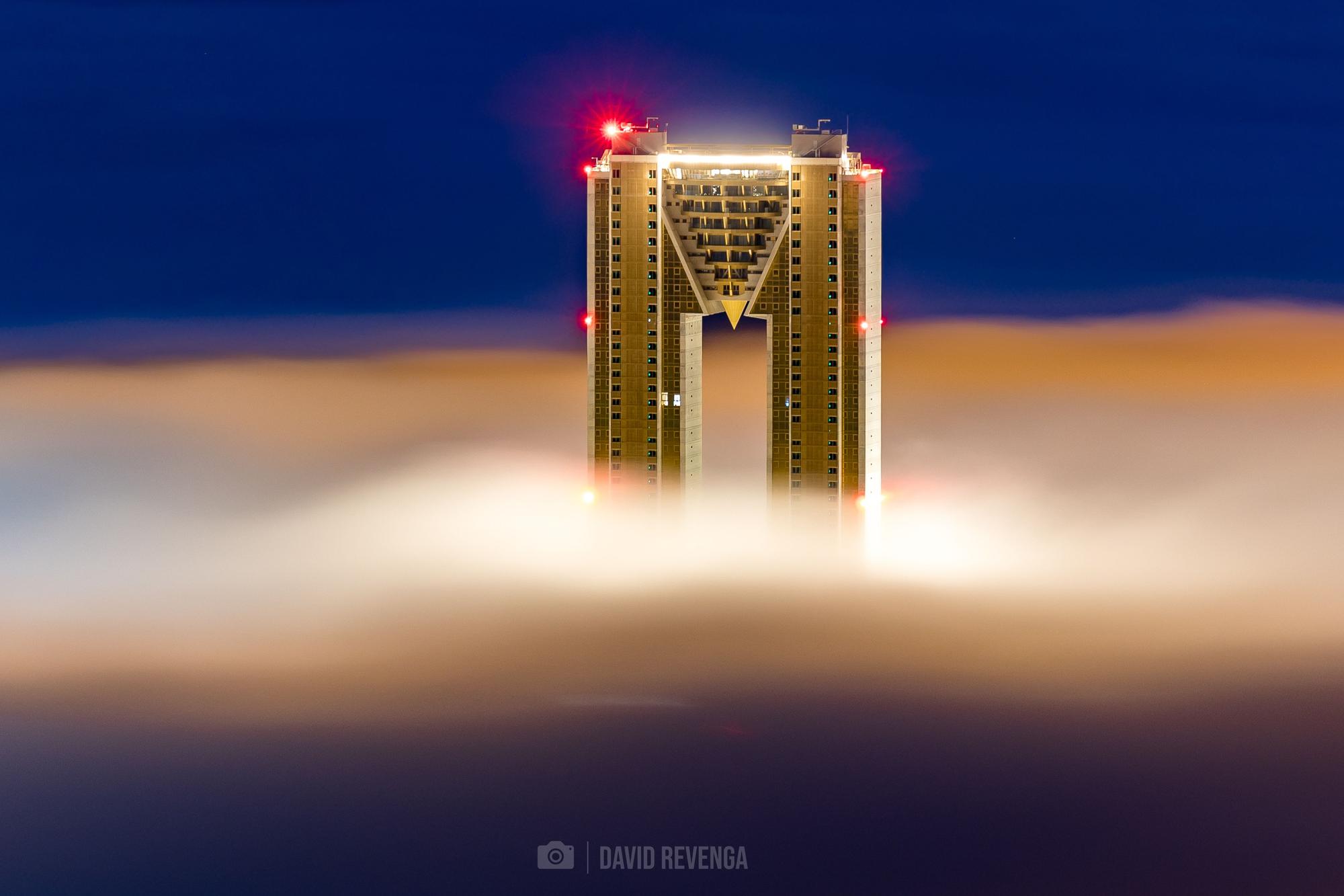 Una columna de niebla que ha entrado desde el mar ha "engullido" las playas y los edificios más cercanos a la primera línea de Benidorm, dejando imágenes del todo singulares de la ciudad.