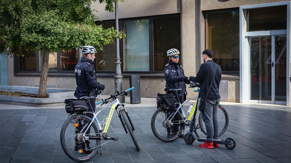 Dos policías locales paran al conductor de un patinete por circular por la acera, en Badajoz.