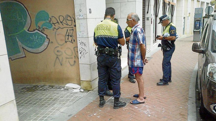 Policías conversando con un vecino con los fragmentos de la losa por los suelos.