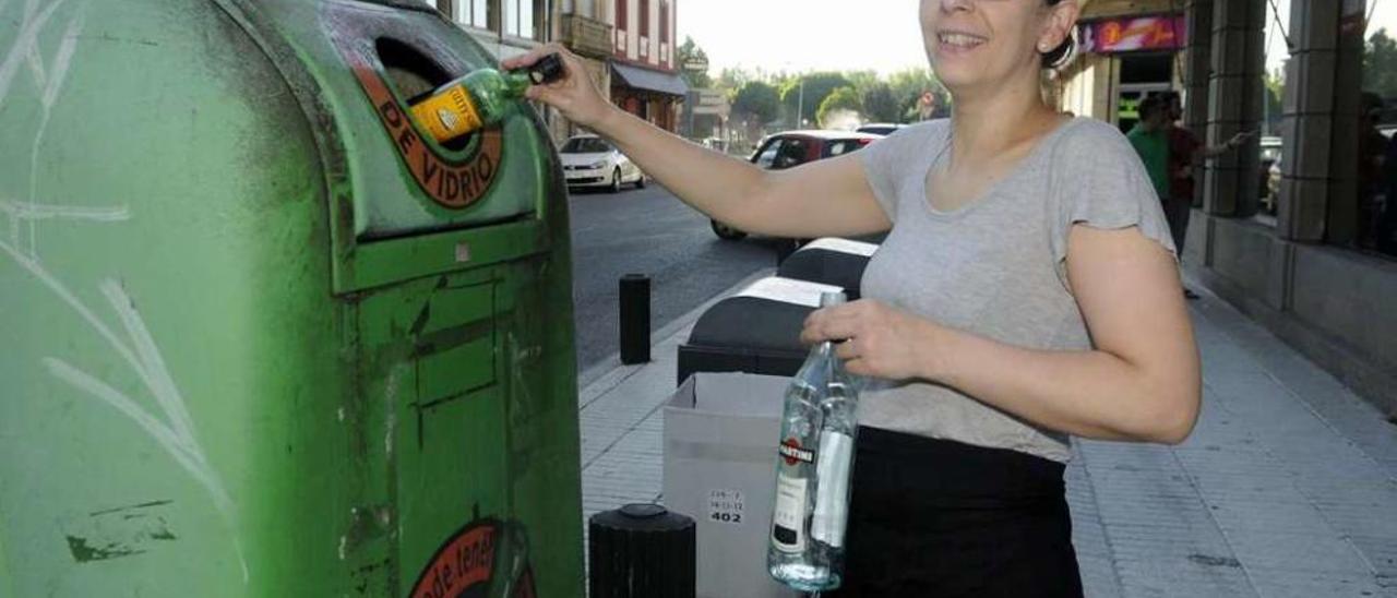 Una mujer depositando botellas de vidrio en uno de los contenedores del centro de Vilagarcía. // Noé Parga