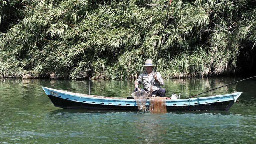 Un pescador en el Azud de la Marquesa, donde la semana pasada bajaba buen caudal de agua, en una imagen de archivo. PILAR CORTÉS