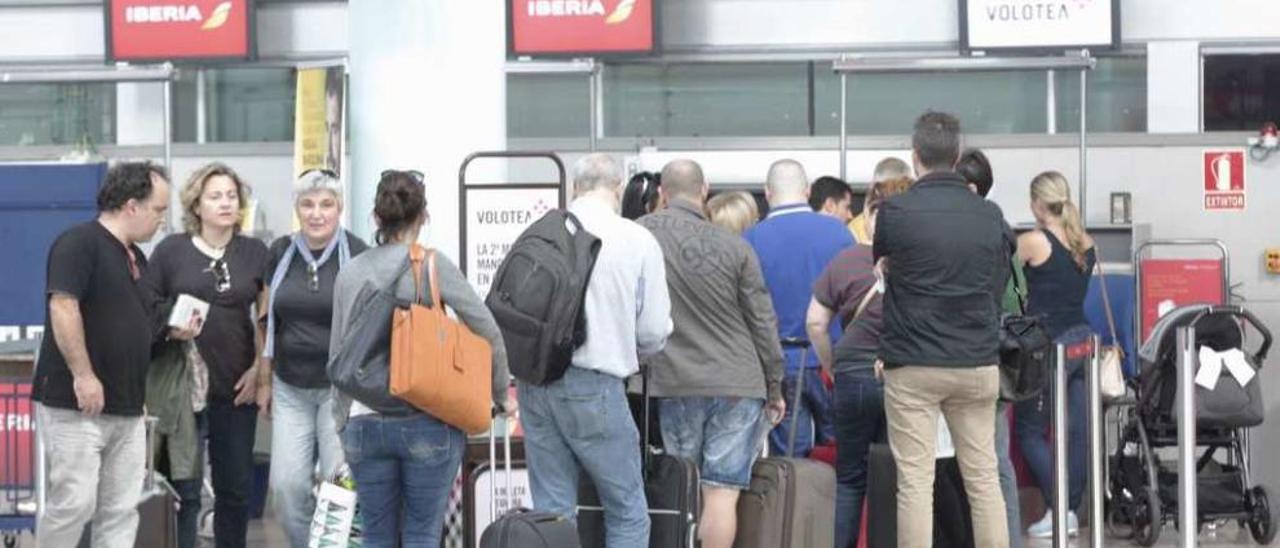 Viajeros facturando ayer sus maletas para el último vuelo Vigo-Valencia de Volotea de 2015. // José Lores