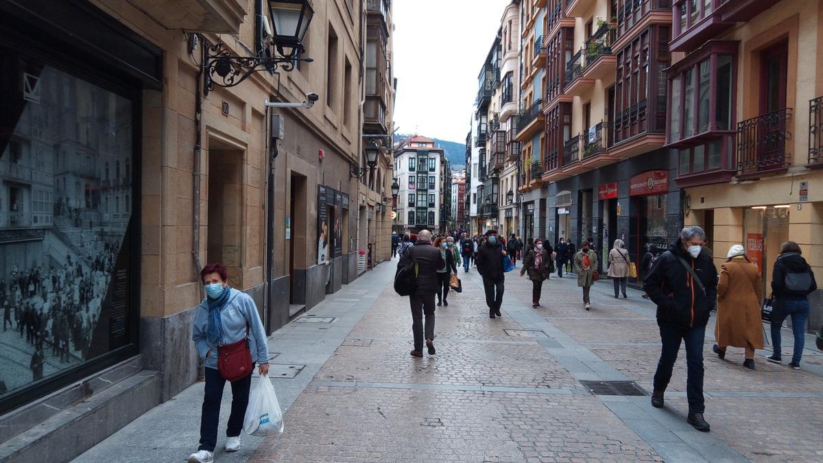 Varias personas con mascarilla en una calle de Bilbao.