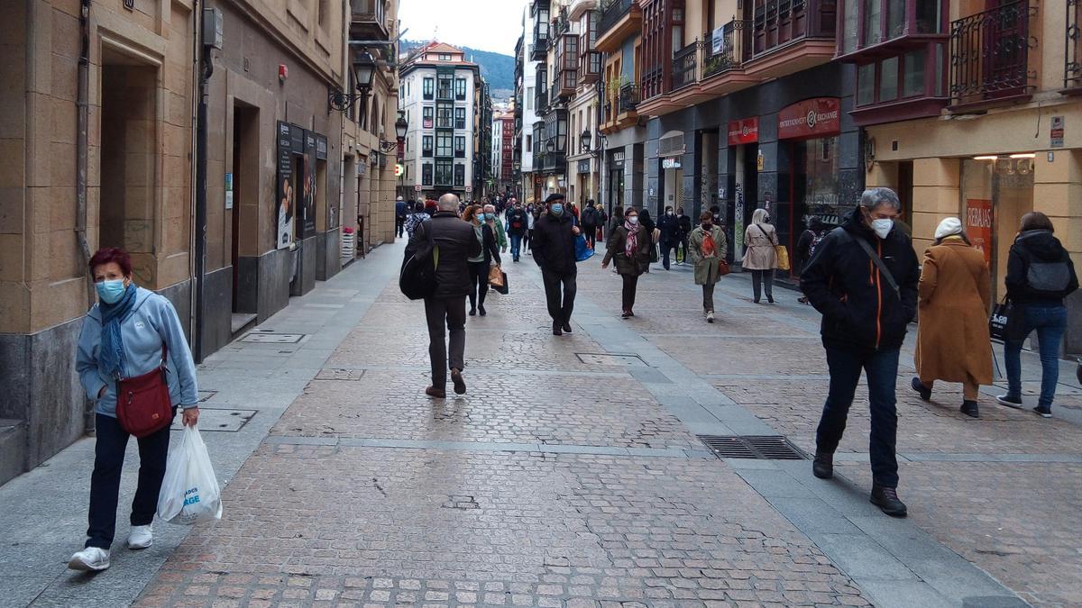 Varias personas con mascarilla en una calle de Bilbao.