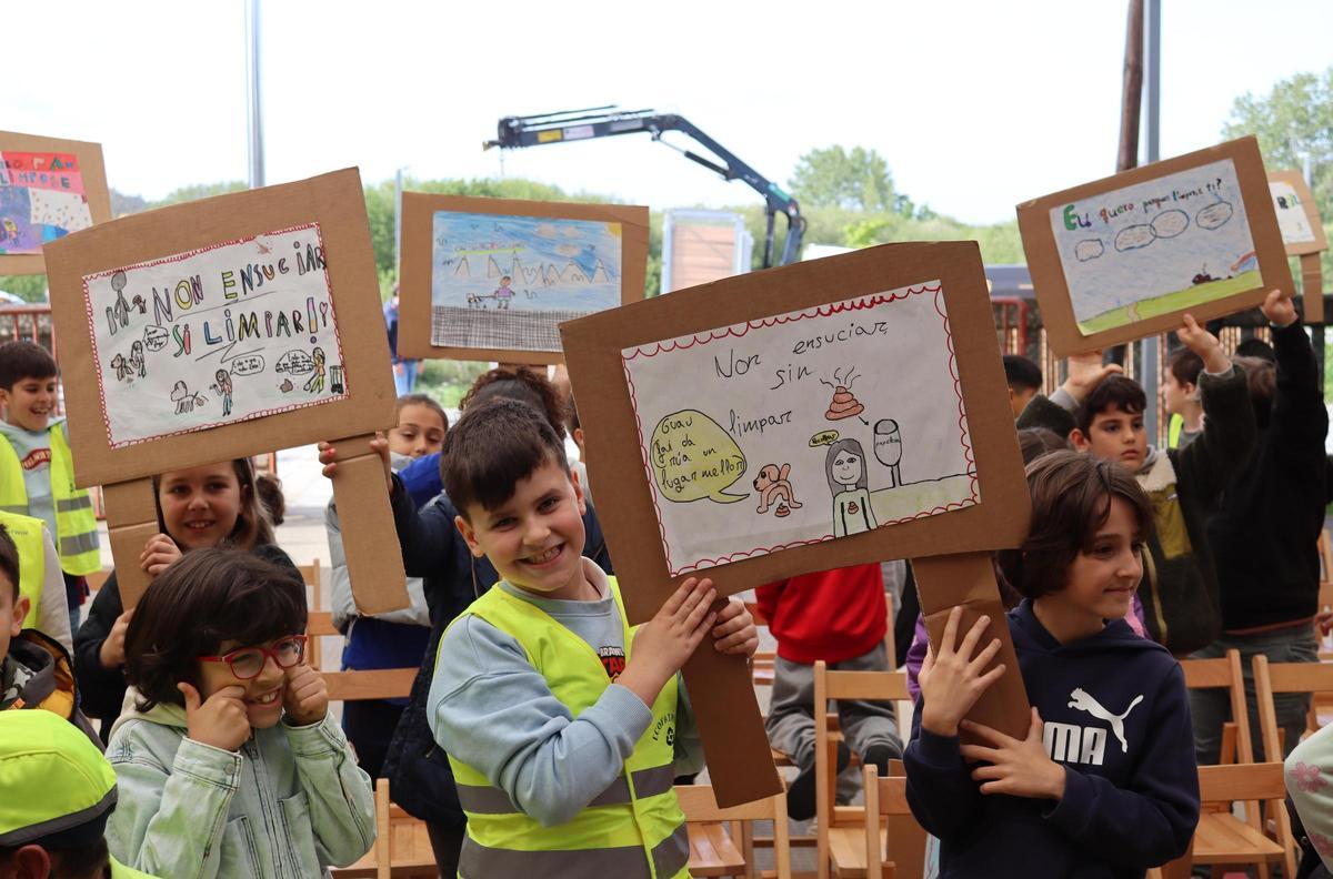 Alumnado do CEIP Plurilingüe A Cristina, de Carballo, coas pancartas nas que reivindican o seu dereito a xogar en espazos públicos limpos.