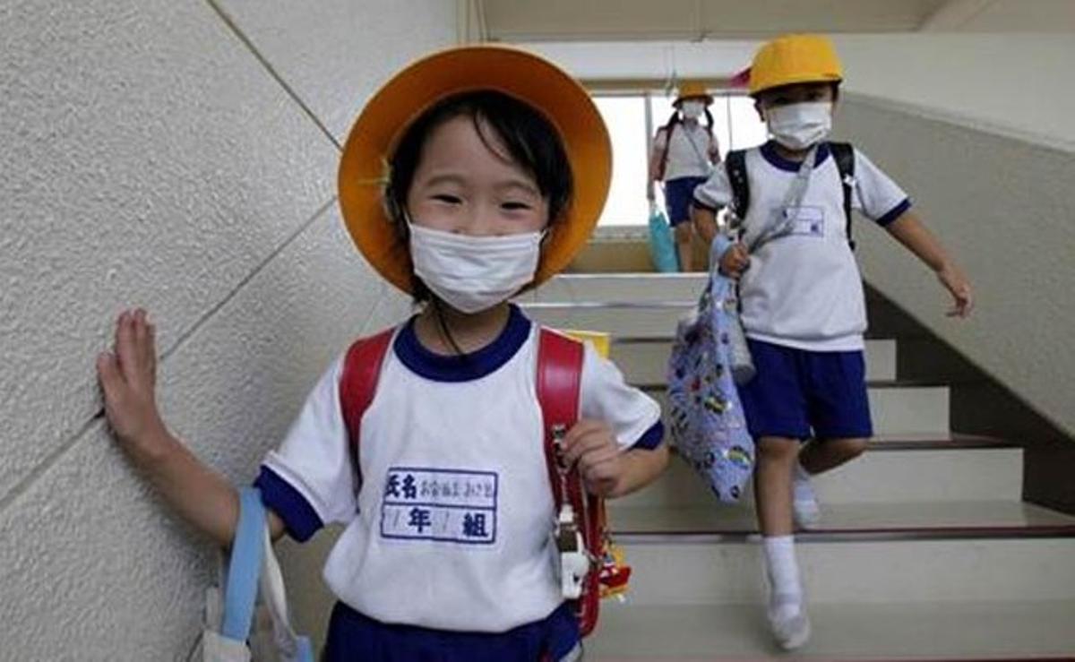Estudiants japonesos usen màscares de protecció per anar a una escola de primària a 20 quilòmetres de Fukushima.