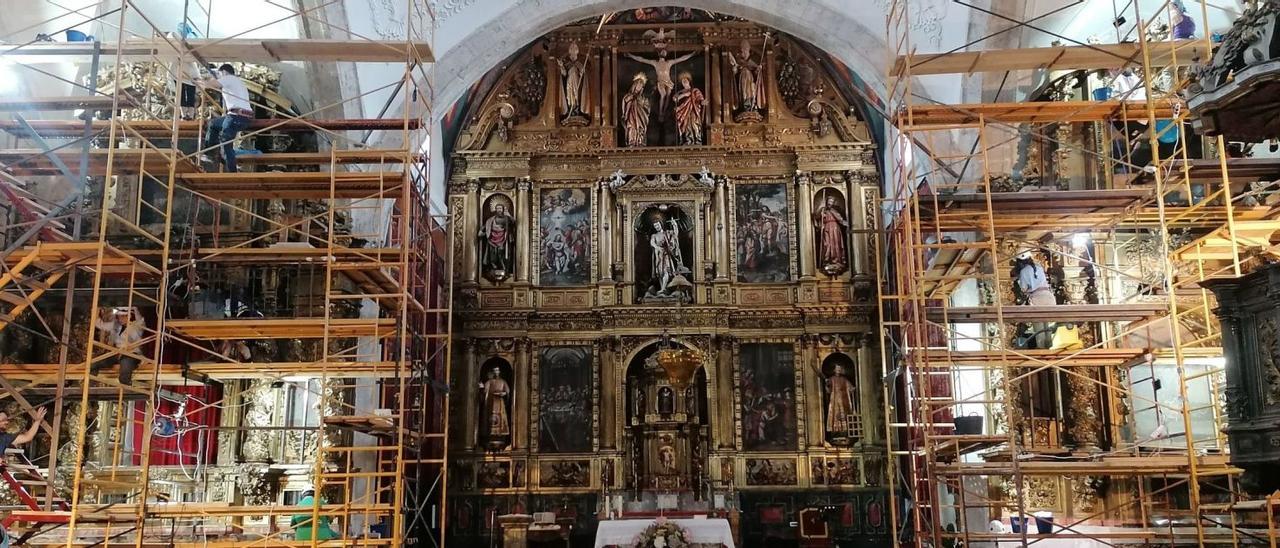 Los alumnos de la Escuela de Restauración de Madrid rehabilitan desde dos andamios dos retablos laterales de la iglesia de San Juan Bautista de Tagarabuena.