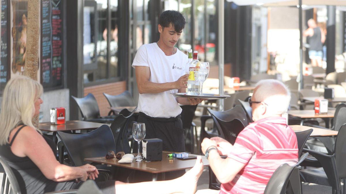 Un camarero atendiendo a unos clientes en Benidorm