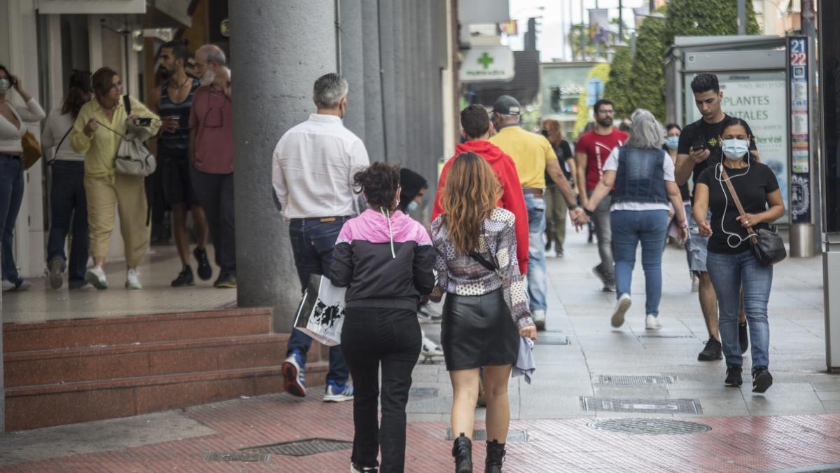 Transeúntes en una calle comercial de Alicante en una jornada festiva de apertura.