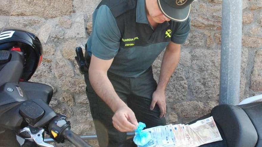 Se incautaron 61 gramos de coca, dinero y la moto. // Guardia Civil