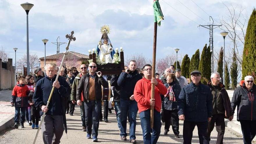 La procesión por las calles de Muelas del Pan con la imagen delante.
