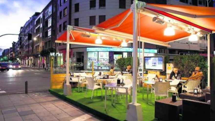 A la izquierda, terraza acondicionada y con televisión en la calle Llanes. A la derecha, varias personas toman el café ayer en una terraza de la plaza Instituto.