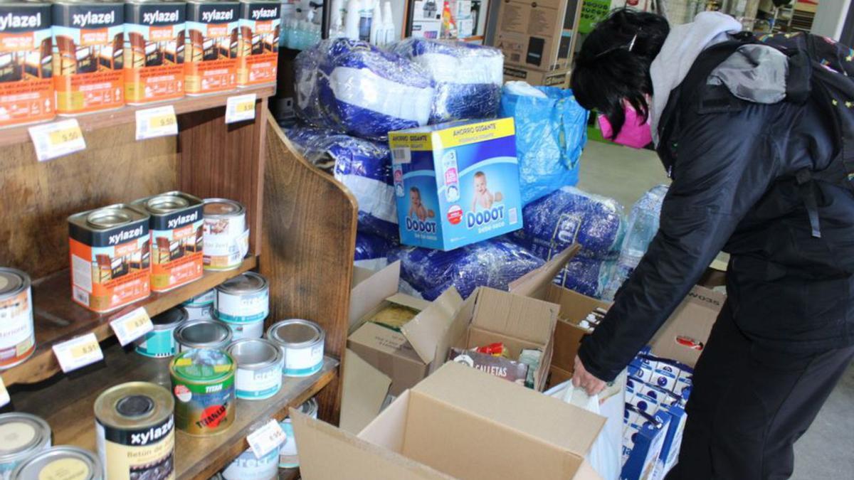 Una mujer deja productos para los ucranianos en la tienda. | A. Saavedra