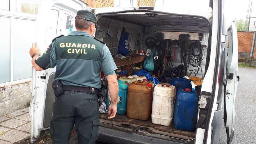 Un agente de la Guardia Civil muestra el combustible intervenido. // FdV