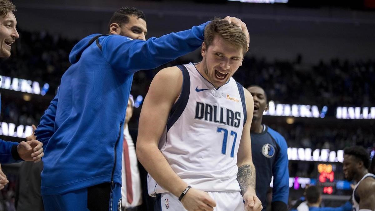 Doncic recibe la felicitación de sus compañeros por anotar 11 puntos seguidos en el partido contra los Rockets