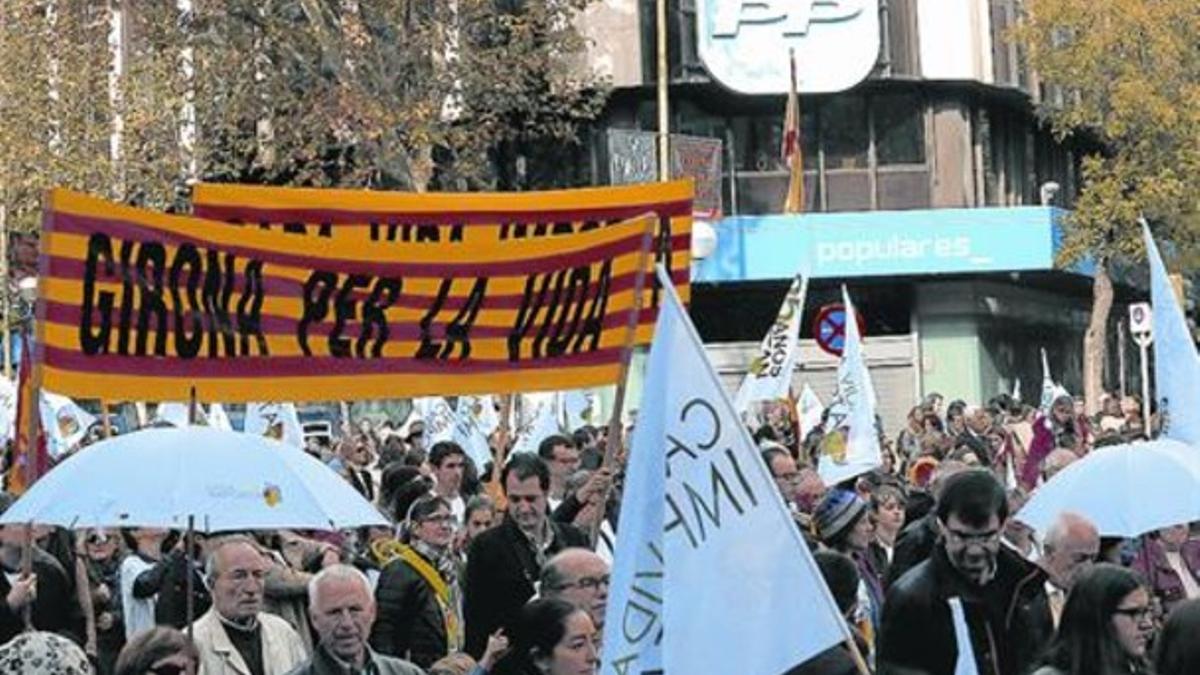 Antiabortistas catalanes, al pasar junto a la sede central del PP, en la calle de Génova, en Madrid, ayer.