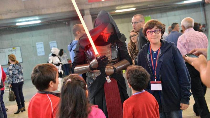 Tres niños saludan a un personaje de la saga de Star Wars.