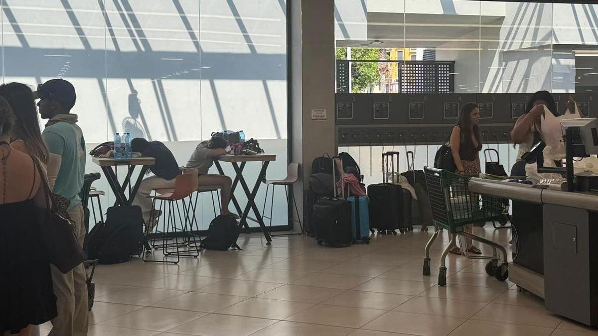 Supermercado con aire de terminal de viajeros: turistas agotados e hilera de maletas