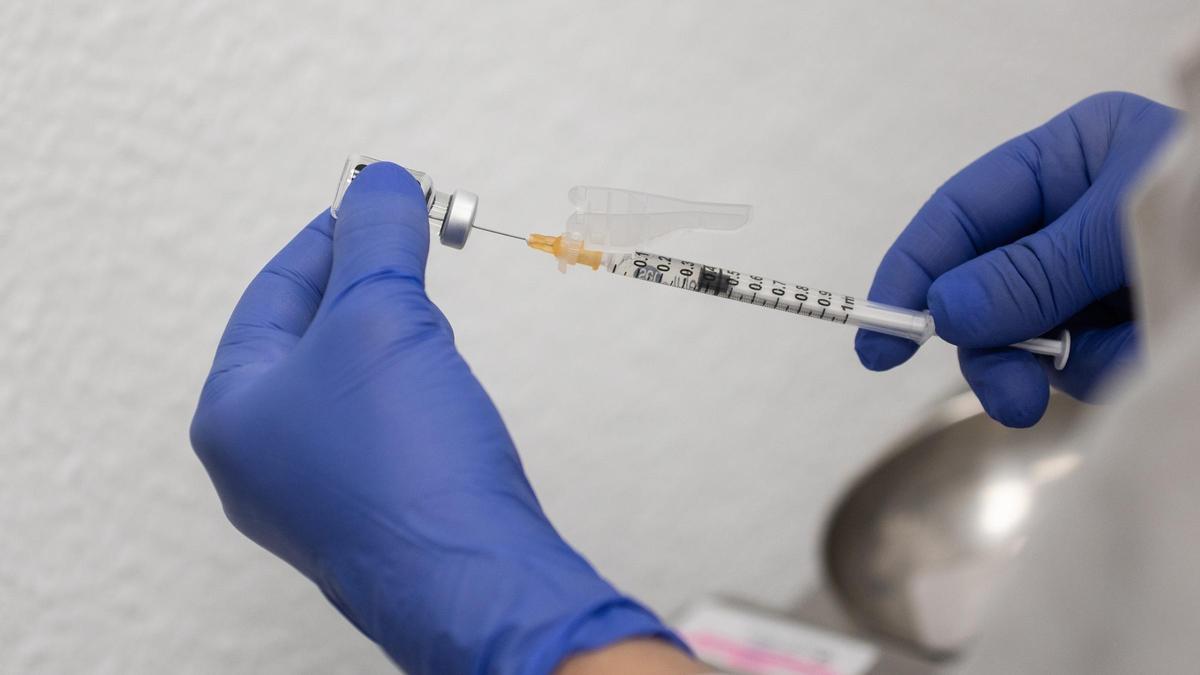 Una sanitaria prepara un vial durante el inicio de la campaña de vacunación de la gripe