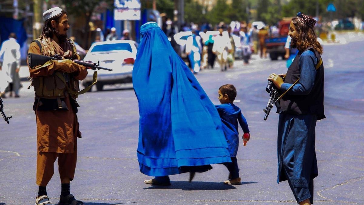 Una mujer camina junto a un niño en Afganistán.