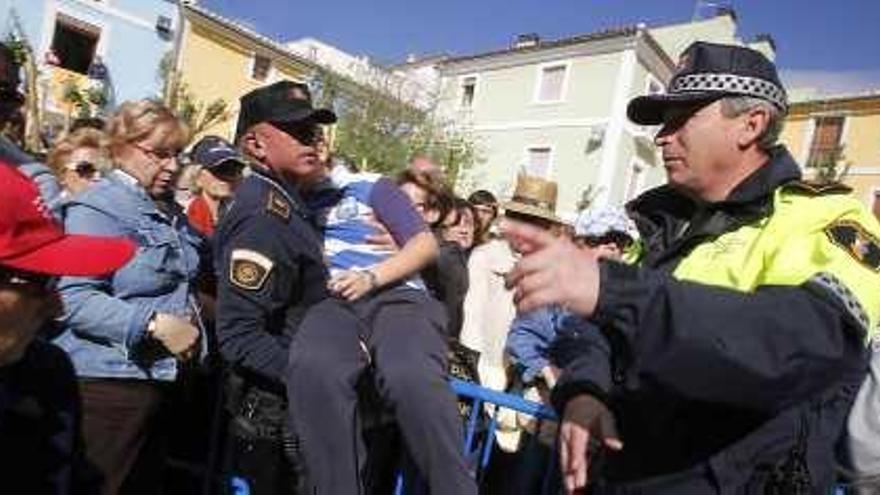 Un policía sostiene a un niño desmayado en la misa.