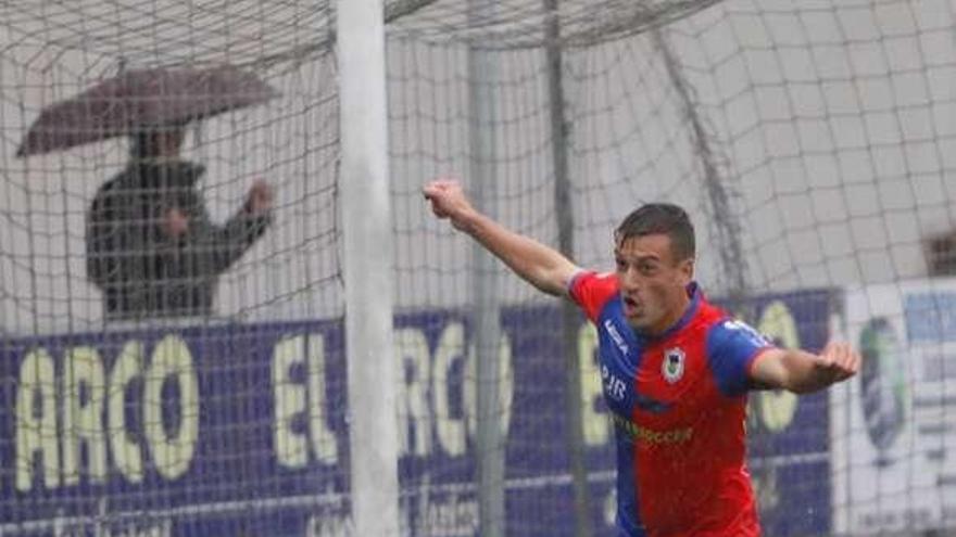 El delantero del equipo langreano Marc Nierga celebra el gol, con el balón dentro de la portería rival.