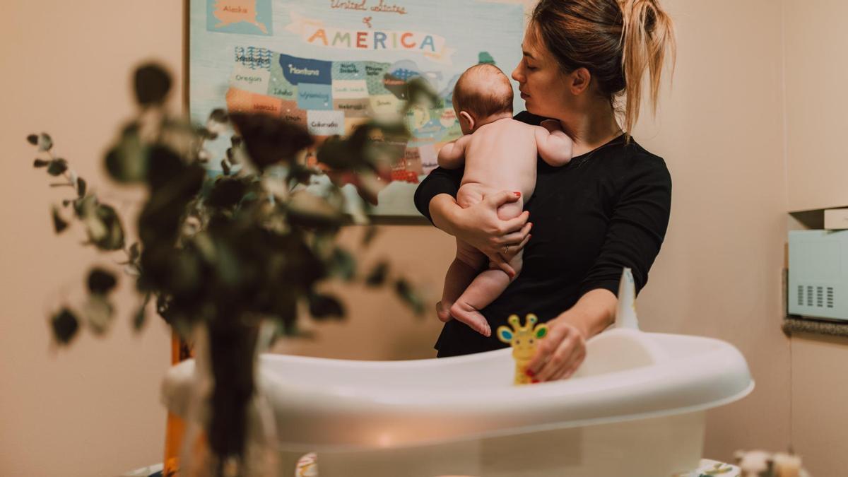 Una madre bañando a su bebé.