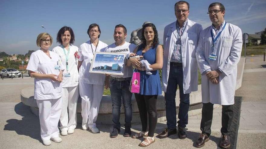 Adrián descansa en los brazos de su madre y su padre, rodeados por profesiones del Chuvi. // C. Graña