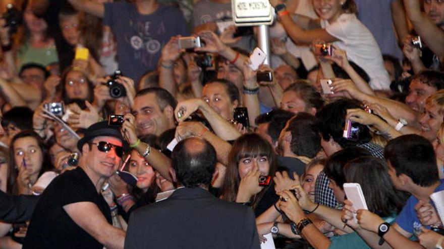 Travolta se fotografía con los fans que le recibieron a su llegada a Donostia.