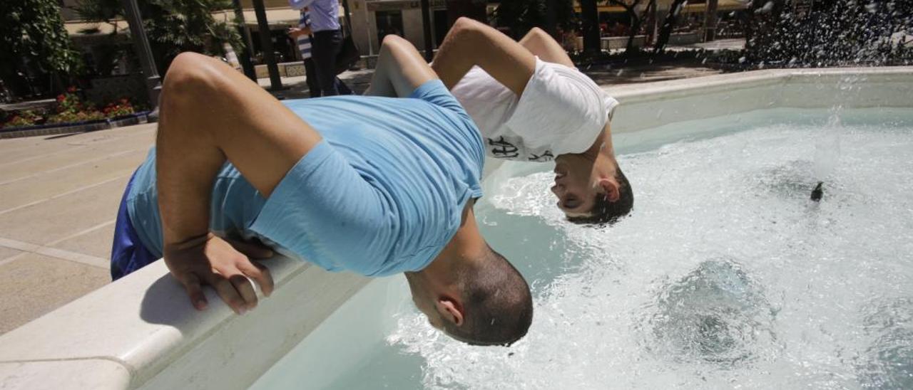 Ilicitanos bañándose o aliviando el calor en diferentes fuentes urbanas.