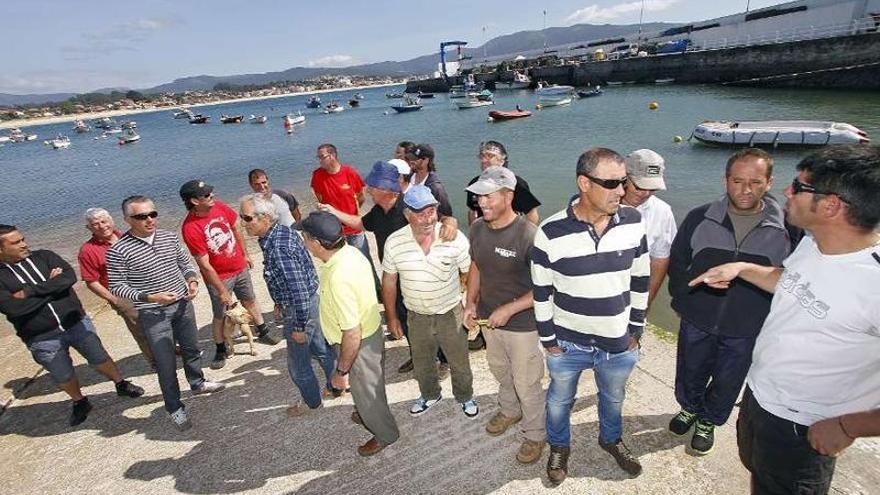 Arriba, los marineros protestan por la negativa de la Xunta a ampliar el espigón. A la izquierda, muestran los destrozos de los temporales en la rampa de varada.