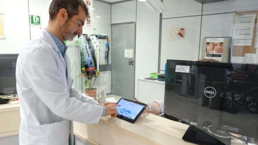 Un sanitario consulta un dispositivo electrónico en las dependencias del hospital. |